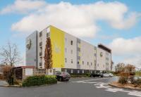 un edificio en un estacionamiento con coches aparcados en B&amp;B HOTEL Arras, en Arras