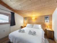 a bedroom with a large white bed with wooden walls at Appartement Megève, 3 pièces, 4 personnes - FR-1-569-63 in Megève