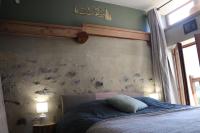 - une chambre avec un lit et une couette bleue dans l&#39;établissement Appartement dans une maison de pays, à Briançon