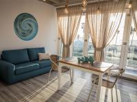 Una sala de estar con un sofá azul y una mesa. en Rosa dei Venti, en Gioia Tauro