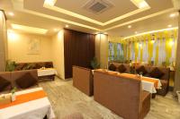 a restaurant with couches and tables and chairs at Apex Business Hotel - Tribhuvan International Airport, Kathmandu in Kathmandu