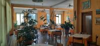 a restaurant with tables and chairs and potted plants at Albergo LA COLDRA in Quarona