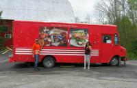 a man and a woman standing in front of a red food truck at Myers Cave Resort in Cloyne