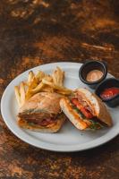 ein Sandwich und Pommes auf einem weißen Teller in der Unterkunft Hotel Michanti in El Zonte