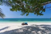 a person sitting in a beach chair on the beach at Sarikantang Resort & Spa, Koh Phangan in Haad Rin