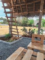 a patio with a bench and a table and a hut at Cosmorama in Auroville