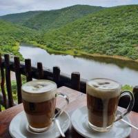 two cups of coffee sitting on a table overlooking a river at 22 Siyanda Mabalingwe in Mabula