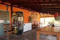 een kamer met tafels en stoelen en een koelkast bij Cachoeiras Pé da Serra in São João Batista do Glória