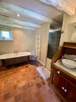 a large bathroom with a tub and a sink at Gîte de la Grange in Colombiers