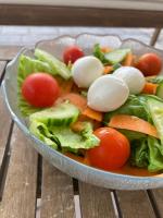 un'insalata in una ciotola su un tavolo di legno di Hotel Rondinella e Viola a Rimini