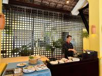 a man standing in front of a table with food at Son Tra Beach Resort & Spa Danang in Da Nang