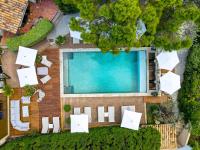 an overhead view of a swimming pool with white chairs at Hotel Bastide & SPA - Villa de Lourmarin in Lourmarin