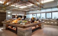 a restaurant with a counter with food on it at Mercure Suzhou Shilu Shantang in Suzhou