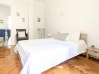 a white bedroom with a large bed and a wooden floor at Apartment Le Rossi by Interhome in Nice