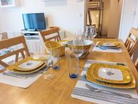 a wooden table with yellow plates and glasses on it at Apartment Domaine de Crespin-3 by Interhome in Saint-Gervais-les-Bains