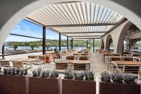 ein Restaurant mit Tischen und Stühlen mit Blick auf das Wasser in der Unterkunft Family Resort del Mar in Pula