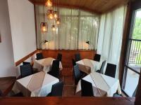 een restaurant met 2 tafels, stoelen en ramen bij Twin House in Ognyanovo