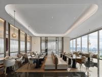 a restaurant with tables and chairs and large windows at Hilton Changshu in Changshu