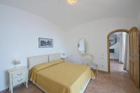 a bedroom with a yellow bed and a mirror at Villa Ambra Positano in Positano