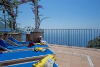 a patio with two lounge chairs on a patio at Villa Ambra Positano in Positano