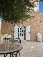een tafel en stoelen voor een gebouw met een deur bij Villa Soun dans la campagne d'ESSAOUIRA in Souk el Had du Drâa