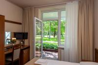 Una habitación de hotel con una cama, un escritorio y una ventana. en Žuvėdra, en Palanga