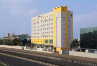 a white and yellow building next to a highway at Holiday Inn Express Chennai OMR Thoraipakkam by IHG in Chennai