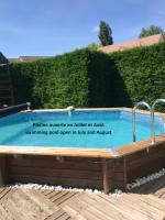 a sign next to a swimming pool in a yard at Maison du Lavoir Disneyland in Bailly-Romainvilliers