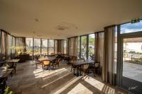 Cussey-les-ForgesにあるAuberge du Molveauのテーブルと椅子と大きな窓のあるレストラン