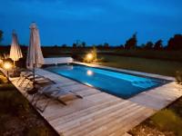 a swimming pool with an umbrella and a deck at Aurefees in Ellon