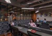 a woman sitting at a table with a laptop at The Millennials Kyoto in Kyoto