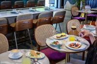 a restaurant with two tables with plates of food at Hotel Poli Urban By AFI Hotels in Tel Aviv