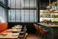 a restaurant with tables and chairs and a bar at Hotel Poli Urban By AFI Hotels in Tel Aviv