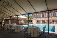 a marquee with tables and chairs next to a swimming pool at Relais La Corte dei Papi in Cortona