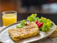 a plate of food with a salad and a glass of orange juice at ibis Itu Plaza Shopping in Itu