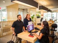 a group of people standing around a desk with a computer at ibis Itu Plaza Shopping in Itu
