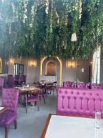 La Nature Hotels & Resorts في Sīkar: مطعم ذو أثاث وطاولات ونباتات أرجوانية
