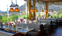 un restaurante con mesas y sillas y vistas a la montaña en Hotel Restaurant Hausberg Garmisch-Partenkirchen, en Garmisch-Partenkirchen