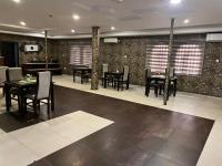 a dining room with black tables and chairs and brick walls at Presken Hotel Shonibare, Maryland, Lagos in Lagos