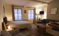 a bedroom with a bed and a living room with a couch at Le Studio du Gouverneur in Honfleur