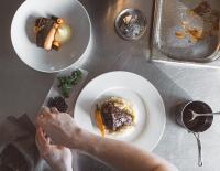 a person sitting at a table with a plate of food at SpaHotel Hamina in Hamina