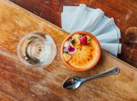 a bowl of food with strawberries on a table with a spoon at SpaHotel Hamina in Hamina