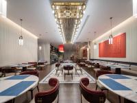 um restaurante com mesas e cadeiras em uma sala em 西安钟楼枫渡酒店旗舰店 em Xian