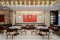 uma sala de jantar com mesas, cadeiras e luzes em 西安钟楼枫渡酒店旗舰店 em Xian