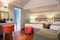 a hotel room with two beds and a table and chairs at Hotel Louvre Bons Enfants in Paris