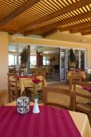 Un restaurante con una mesa con flores sobre un mantel morado. en Futura Hotel, en Máleme