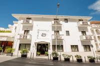 a white building with potted plants in front of it at Hotel La Caravella in Vieste