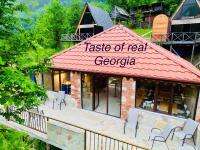 GundauriCheck Inn Merisi Spa and Resort的大楼顶部有标志的餐厅