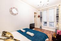 - une chambre avec un lit bleu et une fenêtre dans l&#39;établissement GuestReady - Cozy elegance near attractions, à Paris