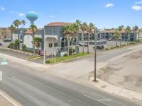 eine leere Straße mit einem Gebäude und Palmen in der Unterkunft South Padre Island Lodge in South Padre Island